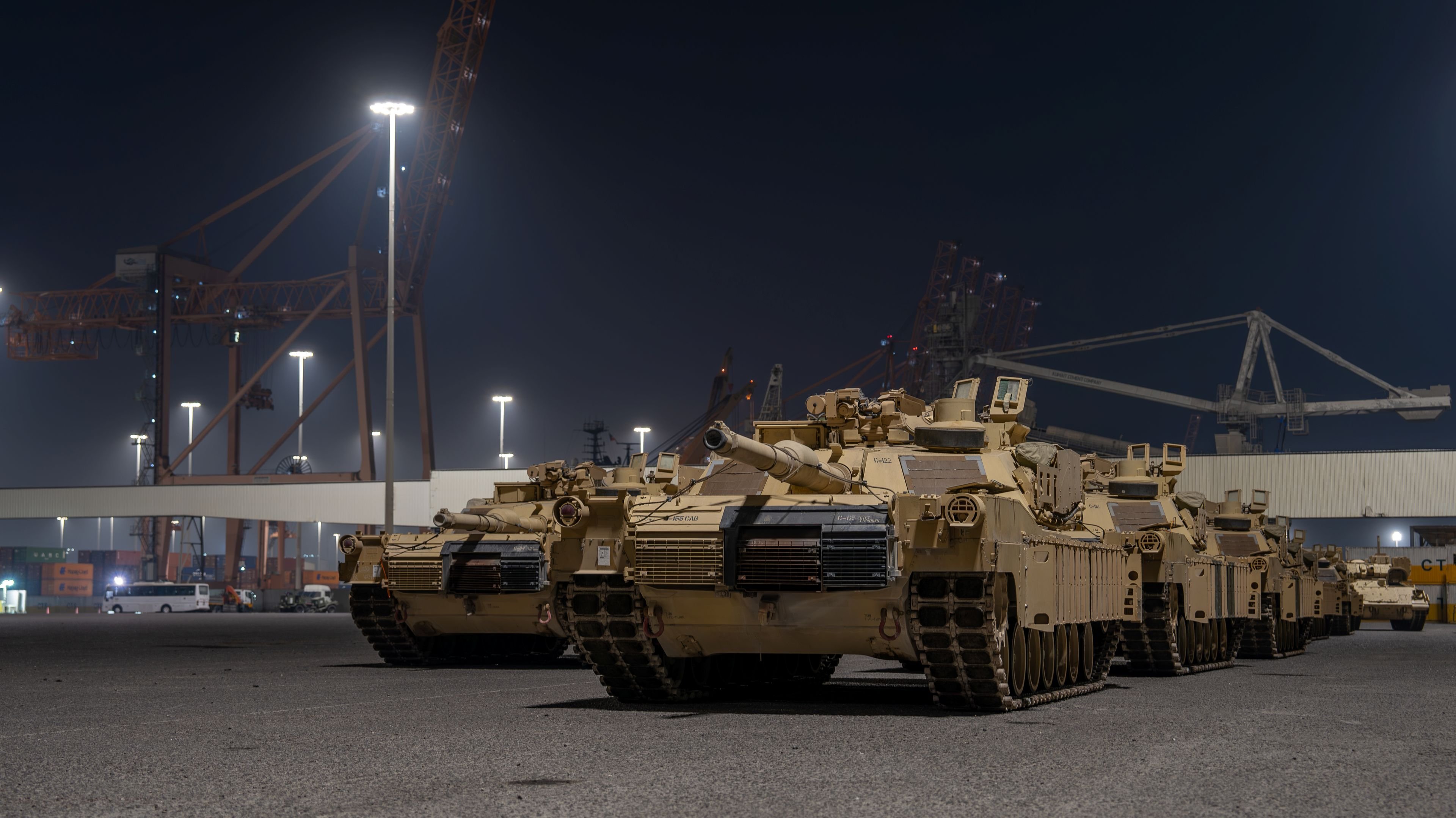 U.S. Army Soldiers with the 840th Transportation Battalion, 595th Transporation Brigade, Surface Deployment and Distribution Command, prepare to load M1 Abrams training tanks onto a vessel during night port operations in support of Exercise Bright Star 23 at Port of Shuaiba, Kuwait, Aug. 13, 2023. Exercise Bright Star 23 is a multilateral U.S. Central Command command-post exercise, field training exercise, and senior leader seminar held in the Arab Republic of Egypt and other partner nations. The exercise strengthens military-to-military relationships and enhances regional security and stability by responding to modern-day security scenarios. (U.S. Army Reserve photo by Capt. Katherine Alegado)
