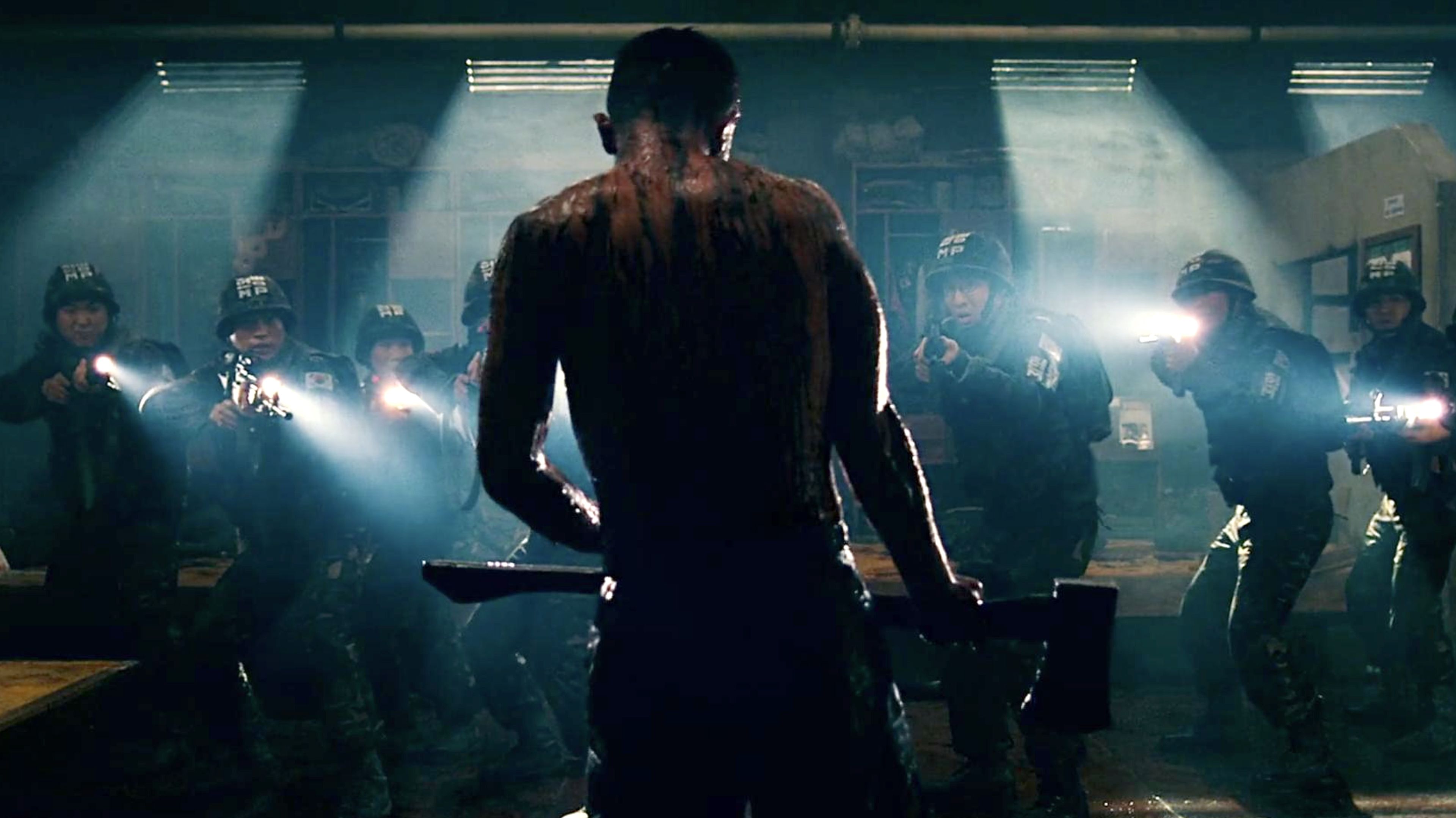 South Korean soldiers aim rifles and flashlights at a blood-covered man inside a military installation in The Guard Post.