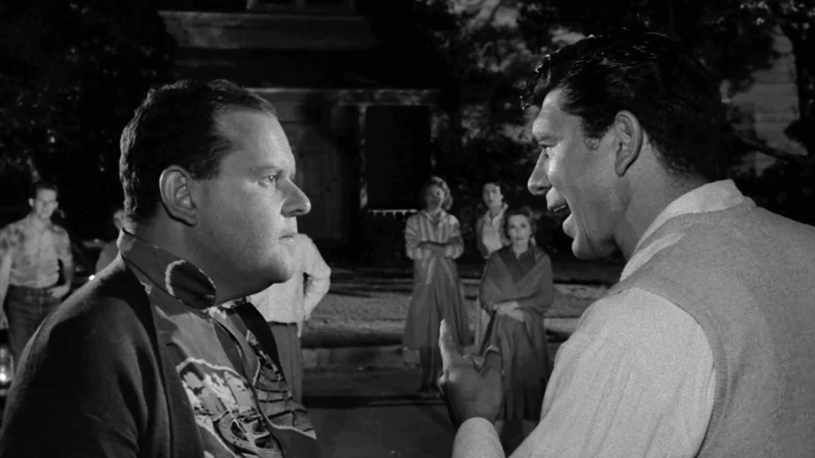 Two men confront one another as frightened neighbors watch in The Twilight Zone episode “The Monsters Are Due on Maple Street.”