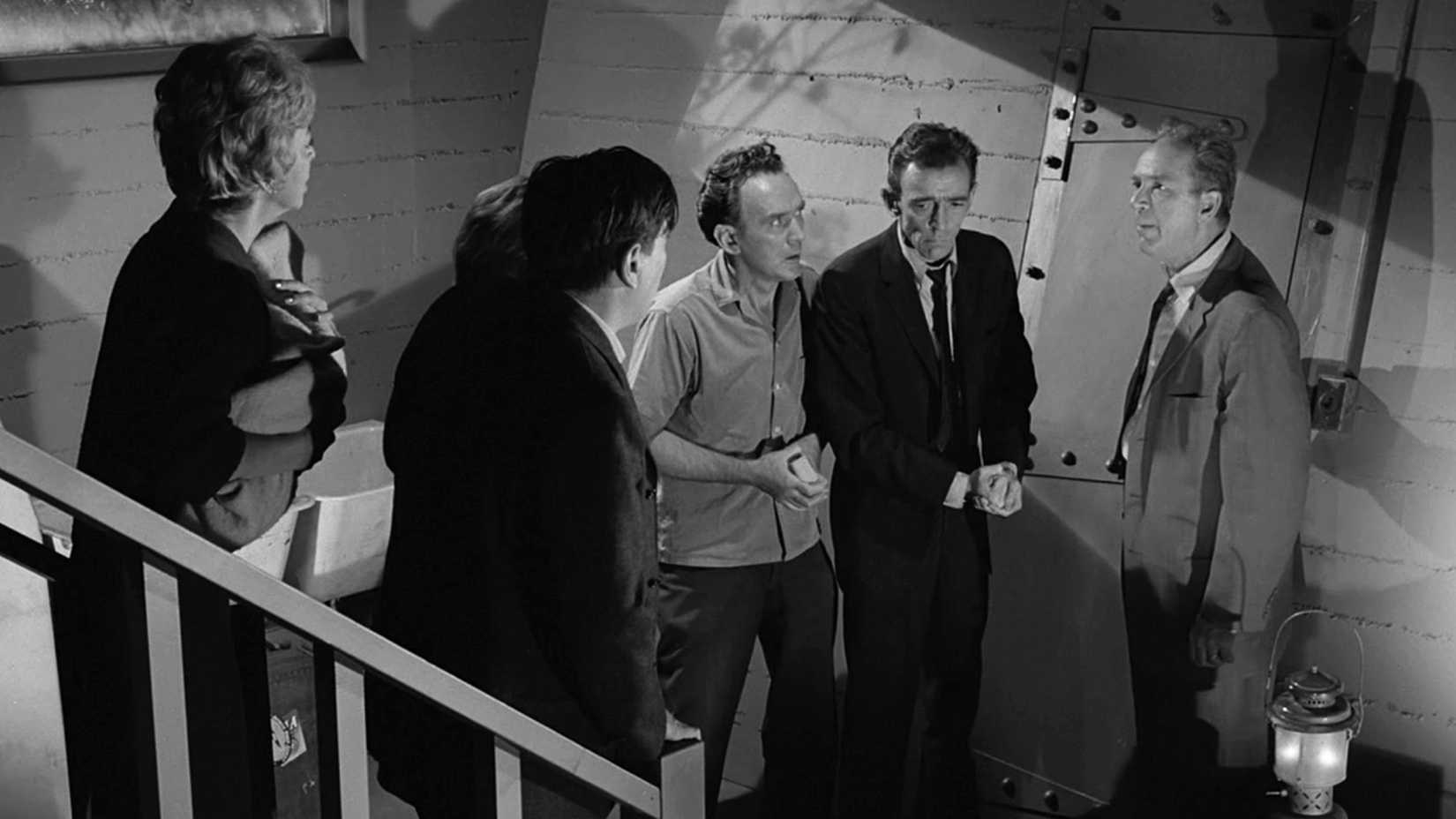 A group of frightened neighbors gathers inside a basement fallout shelter in The Twilight Zone episode “The Shelter.”