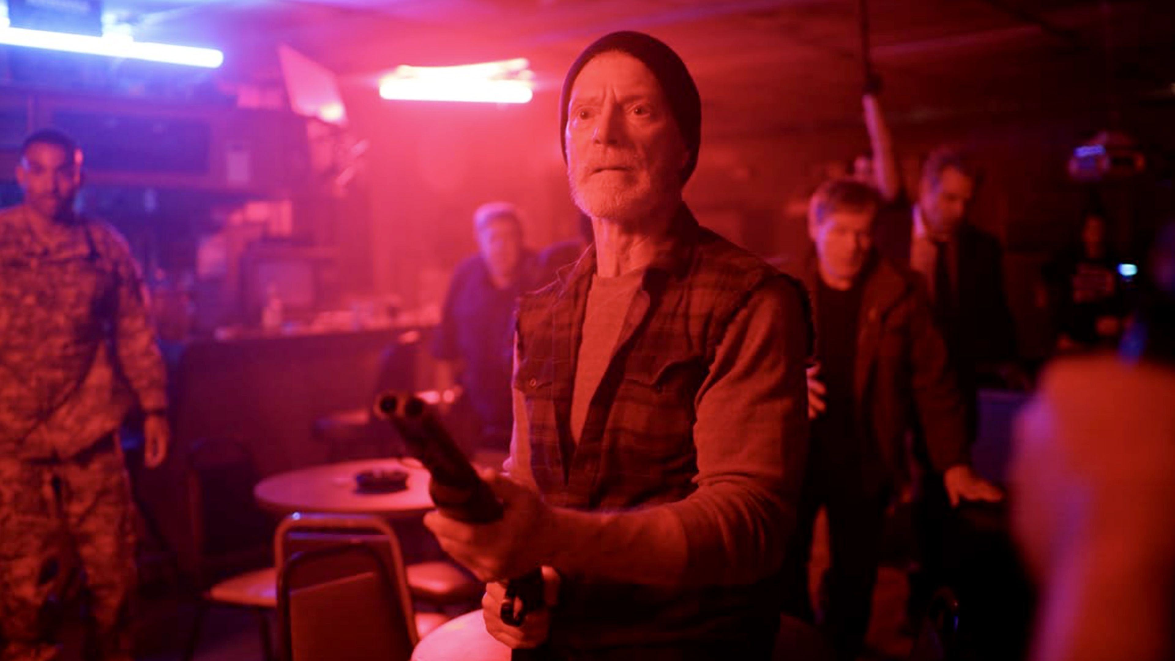 Stephen Lang holds a shotgun inside a VFW post while other veterans stand behind him in the horror movie VFW.